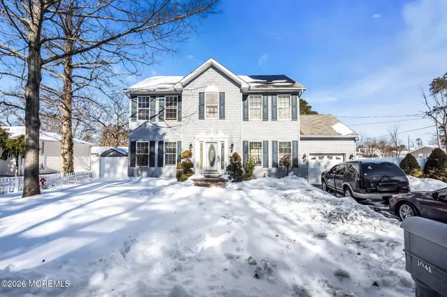 a view of a white house with a large windows in front of house
