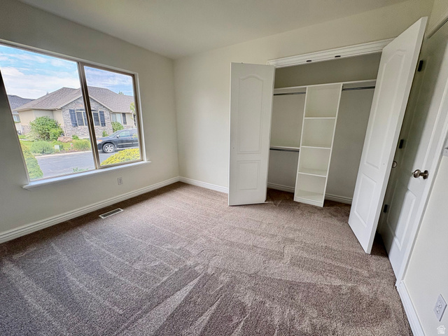 665 West State Road Lehi, UT 84043 - Photo 12 of 30 Bright room featuring a large window, neutral carpeting, and a built-in closet with shelving and hanging rods