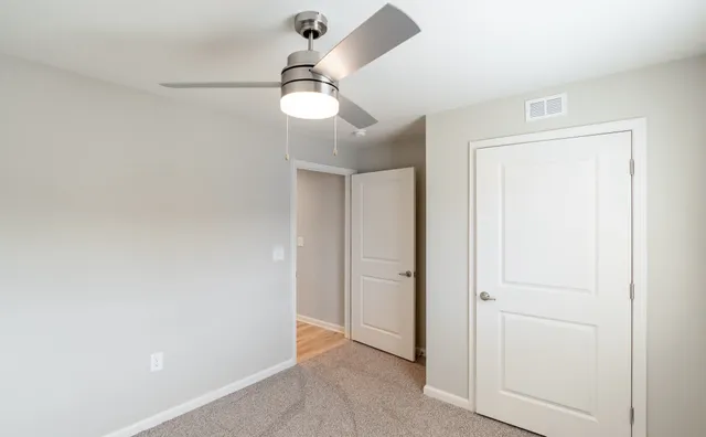 a view of a room with a stylish ceiling fan and entryway