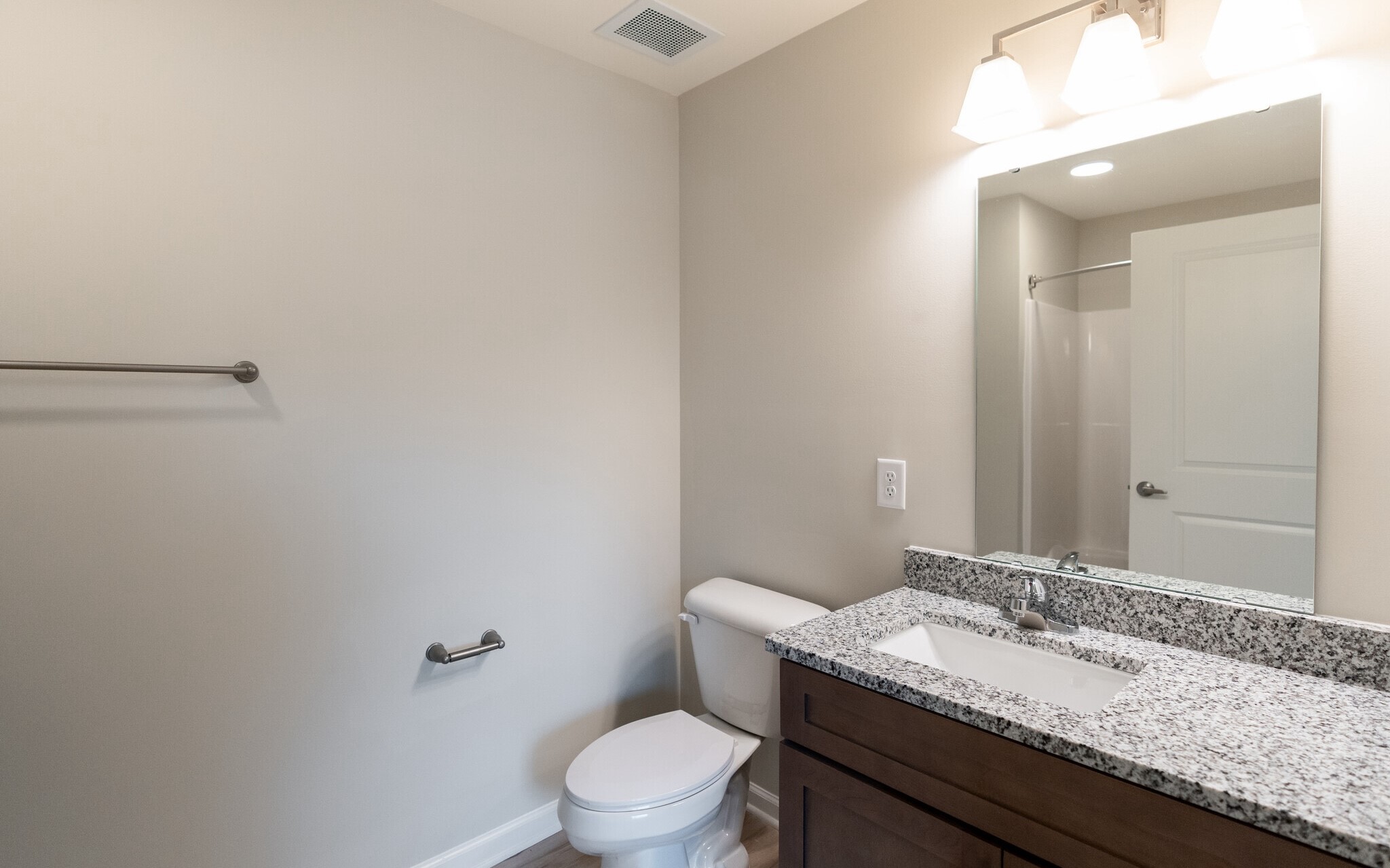 3432 Carr Road Durham, NC 27703 - Photo 21 of 28 a bathroom with a granite countertop sink a toilet and a mirror