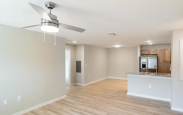 a view of a kitchen with wooden floor and a ceiling fan
