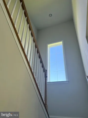 a view of staircase with wooden floor and white walls