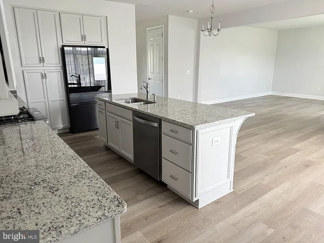 a kitchen with granite countertop a sink stove and refrigerator