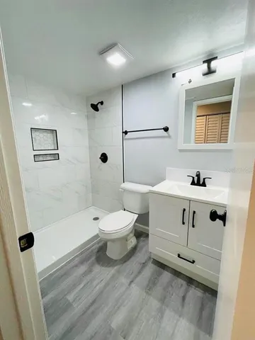 a bathroom with a sink a toilet and shower