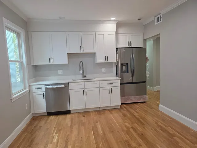 a kitchen with a refrigerator sink and cabinets