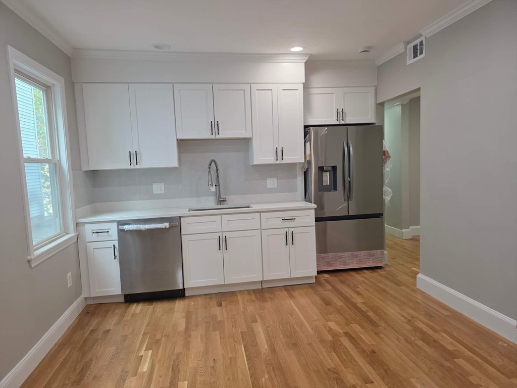574 Washington Street, Unit 2 Boston, MA 02135 - Photo 3 of 11 a kitchen with a refrigerator sink and cabinets