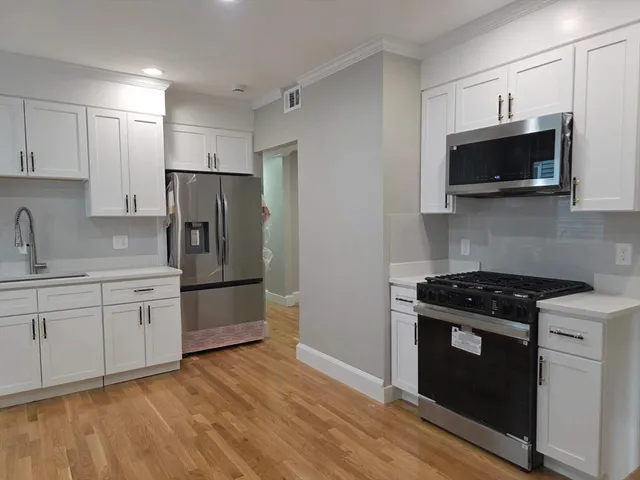 a kitchen with stainless steel appliances a stove a microwave a sink and cabinets