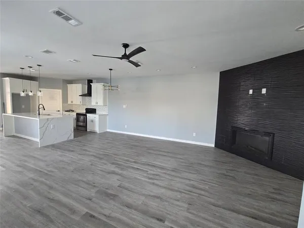 a view of a kitchen with wooden floor and a kitchen space