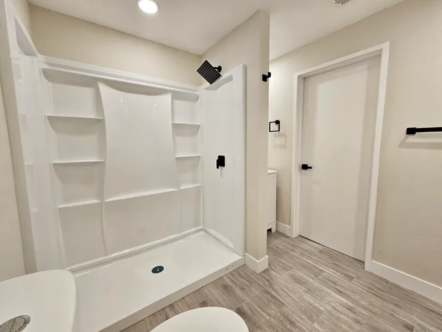 an empty room with a ceiling fan and a window