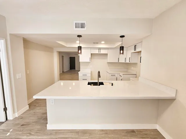 a view of kitchen with sink and refrigerator