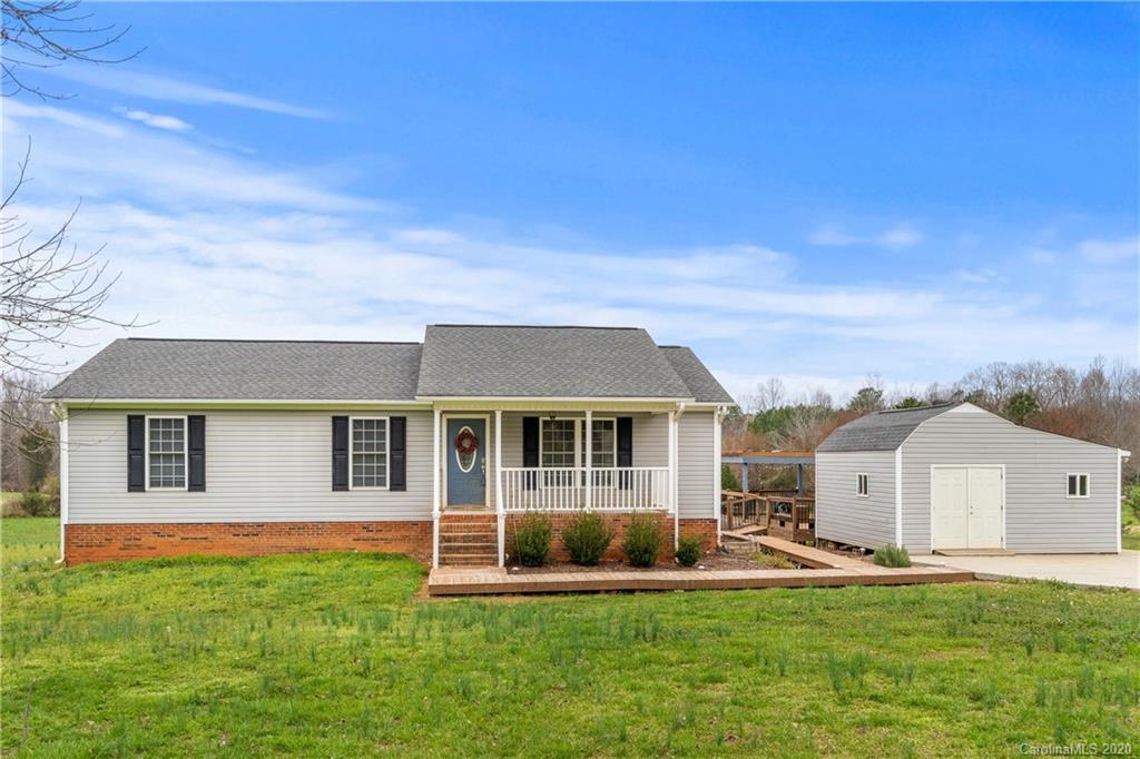 a view of a house with a yard and sitting area