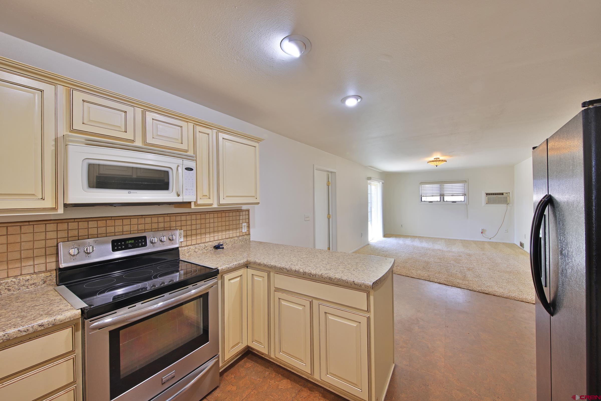 13637 Happy Hollow Road Eckert, CO 81418 - Photo 12 of 38 a kitchen with stainless steel appliances granite countertop a stove microwave and refrigerator