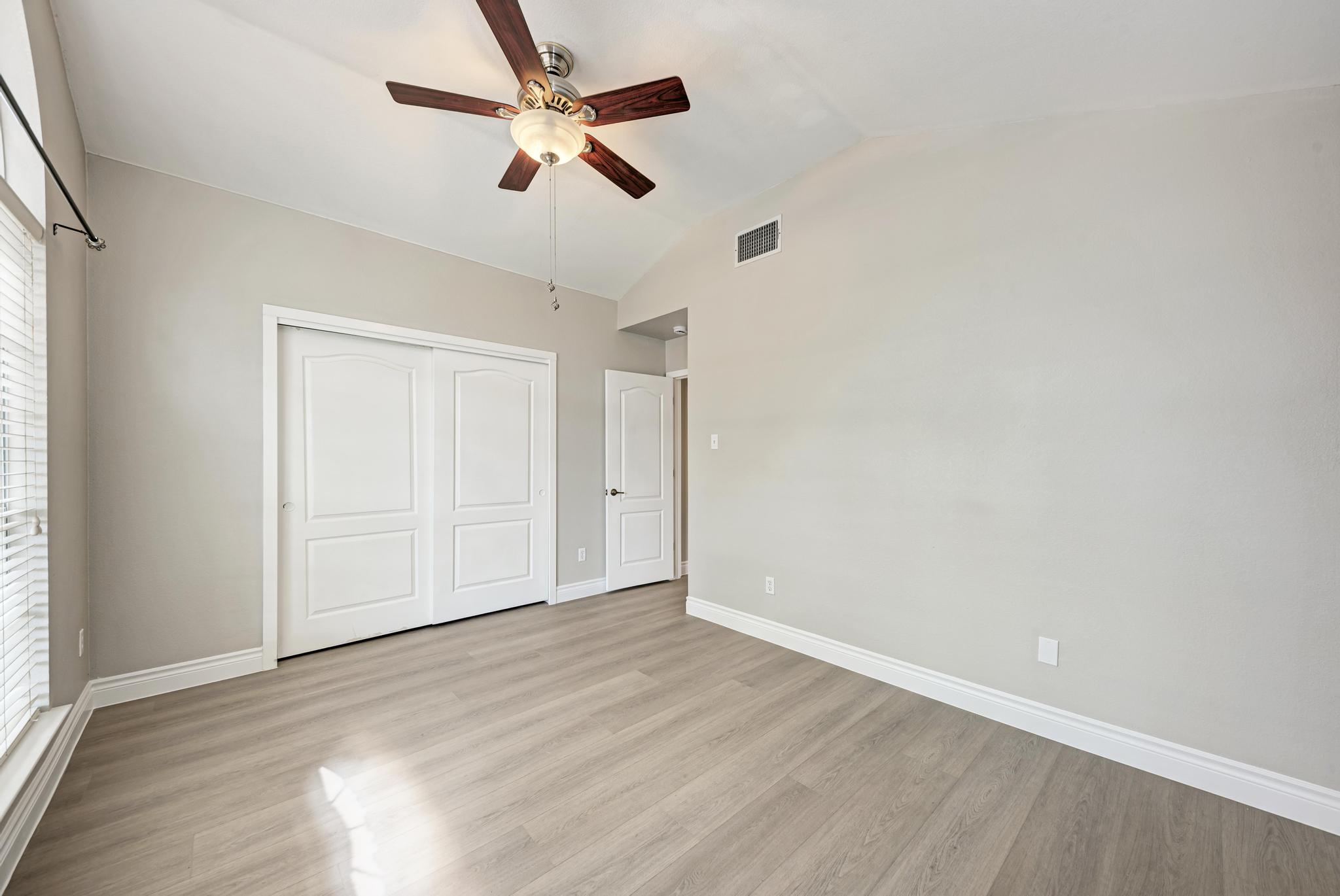 4408 Tello Path Austin, TX 78749 - Photo 26 of 38 Unfurnished bedroom featuring lofted ceiling, light wood-style flooring, a closet, and multiple windows