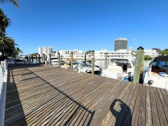 a view of a rooftop deck with dining table and chairs with wooden floor