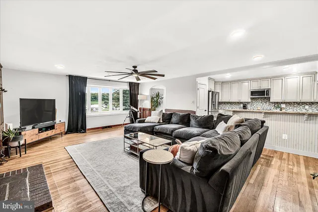 a living room with furniture a flat screen tv and a large window