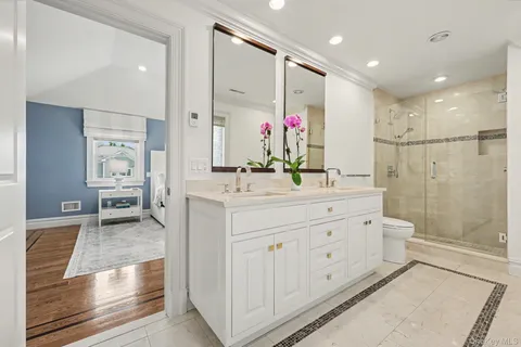 a bathroom with a double vanity sink mirror and shower
