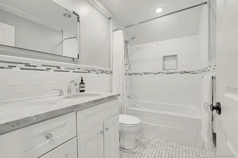 a bathroom with a granite countertop sink a toilet and shower