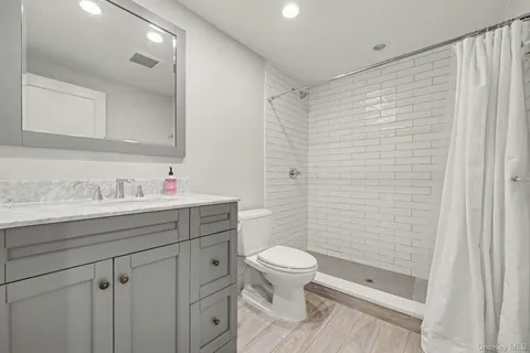 a bathroom with a sink a toilet and shower