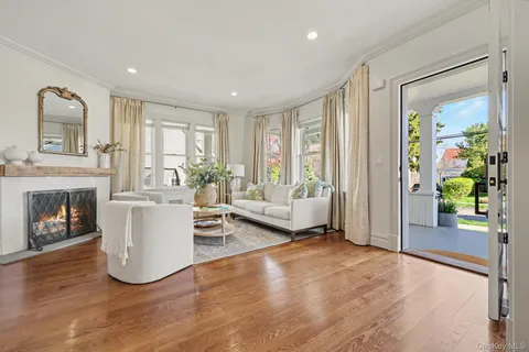 a living room with furniture a fireplace and a large window