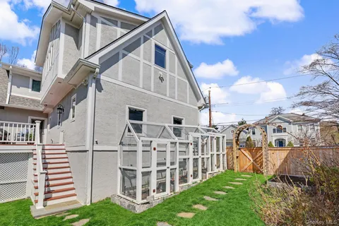 a view of a white house with iron fence