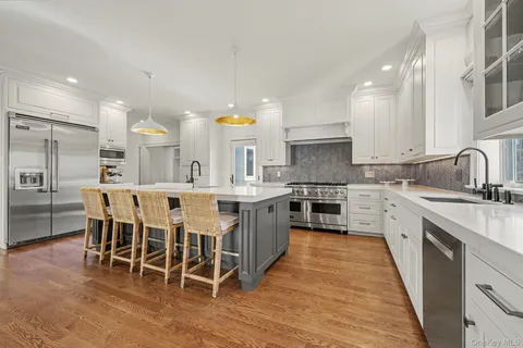 a large kitchen with a center island and stainless steel appliances