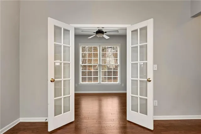 a view of an empty room with wooden floor and a window