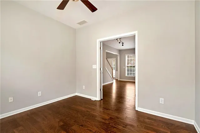 a view of an empty room with wooden floor and a fireplace