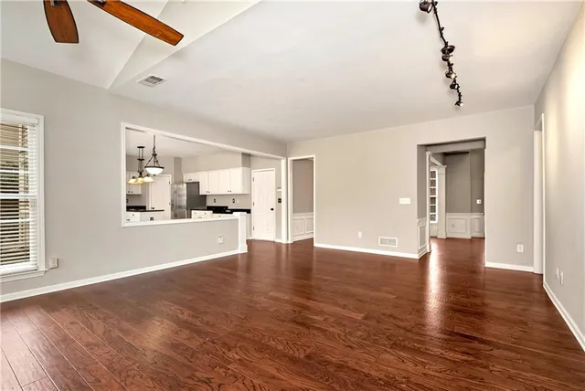 a kitchen with stainless steel appliances kitchen island granite countertop a stove a refrigerator a sink a oven and a wooden floors