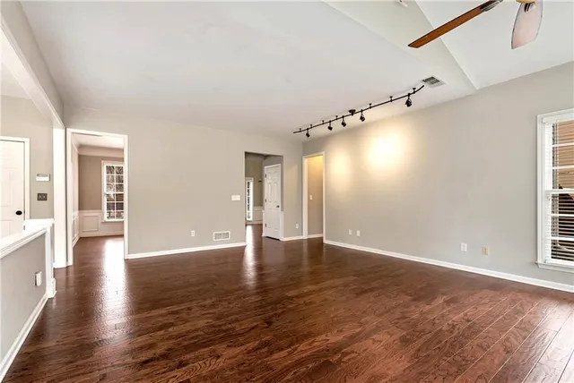 a open kitchen with stainless steel appliances a stove top oven and a wooden floor