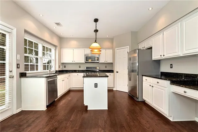 a view of a kitchen with a stove wooden floor and a large window