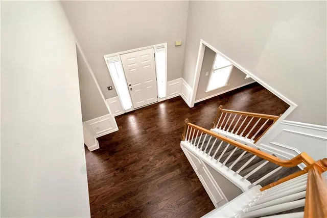 a view of empty room with wooden floor and ceiling fan