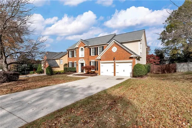 a view of a brick house with plants and large windows