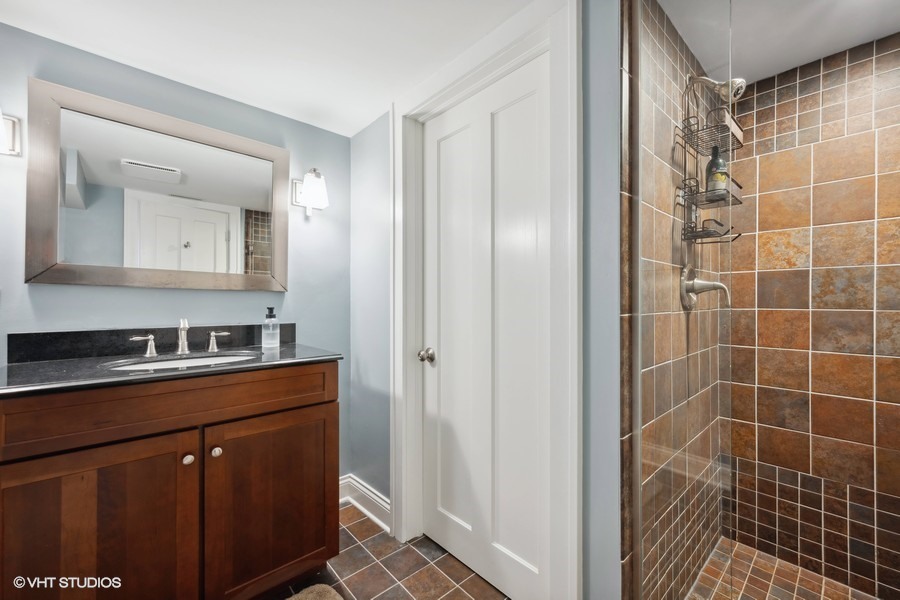 807 Cherry Street Winnetka, IL 60093 - Photo 28 of 37 a bathroom with a double vanity sink a mirror and a shower