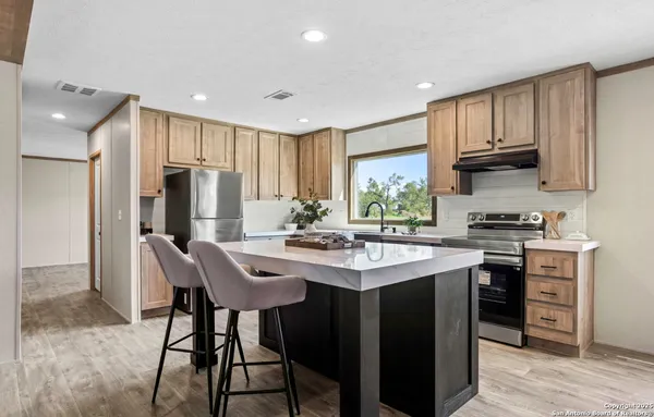 a kitchen with stainless steel appliances a sink stove and refrigerator