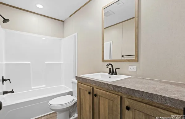 a bathroom with a granite countertop sink a toilet and shower