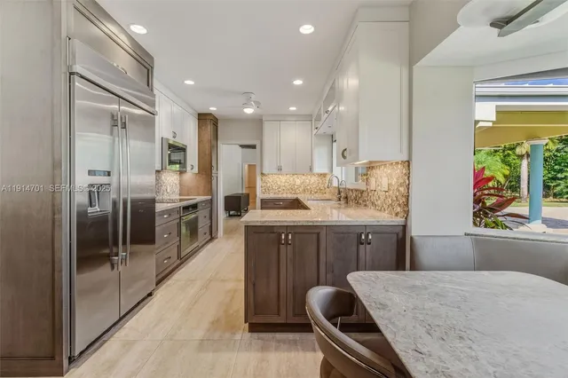 a kitchen with a refrigerator and a stove top oven