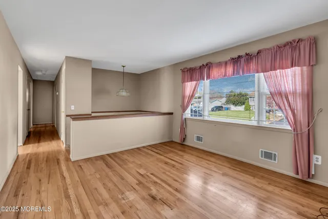 a view of a hallway with wooden floor and door