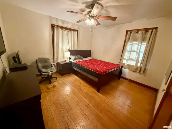 a bedroom with a bed and wooden floor