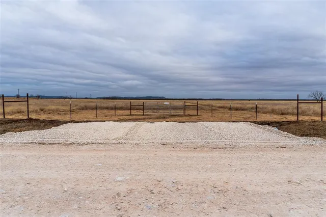 a view of yard with large trees and covered with wooden fence