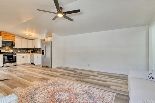 a view of kitchen with wooden floor and electronic appliances