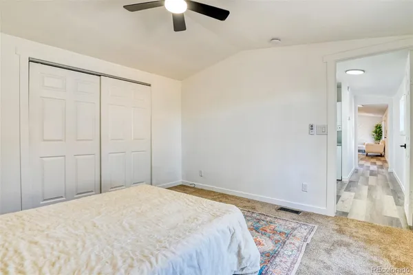 a bedroom with a bed and a chandelier fan