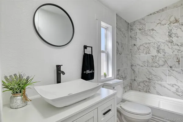 a bathroom with a sink a toilet and a mirror