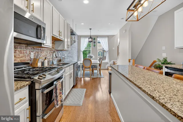 a kitchen with stainless steel appliances granite countertop wooden cabinets a stove top oven a sink and dishwasher