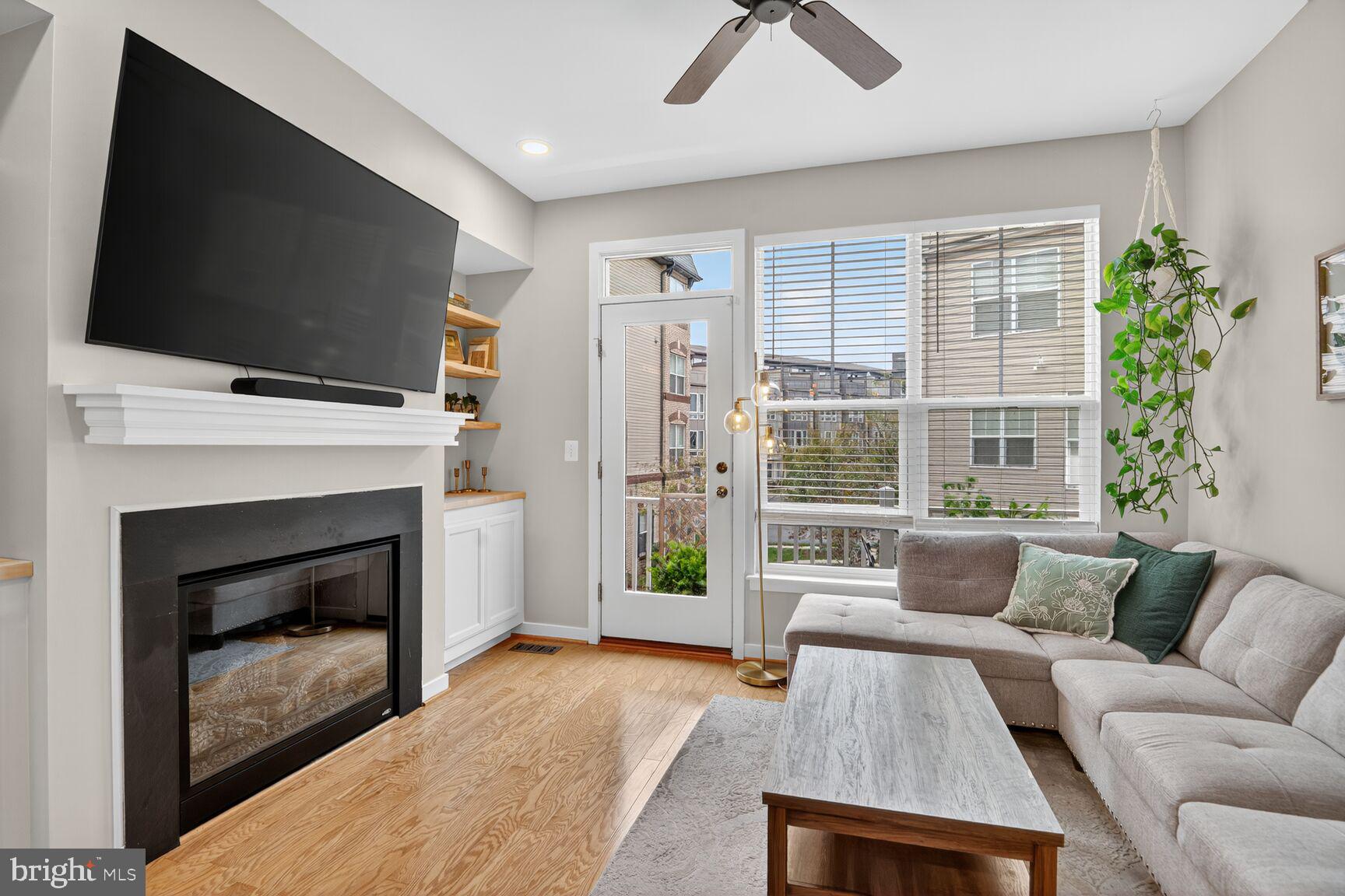 1449 Trafalgar Lane Frederick, MD 21701 - Photo 11 of 28 a living room with furniture a flat screen tv and a fireplace