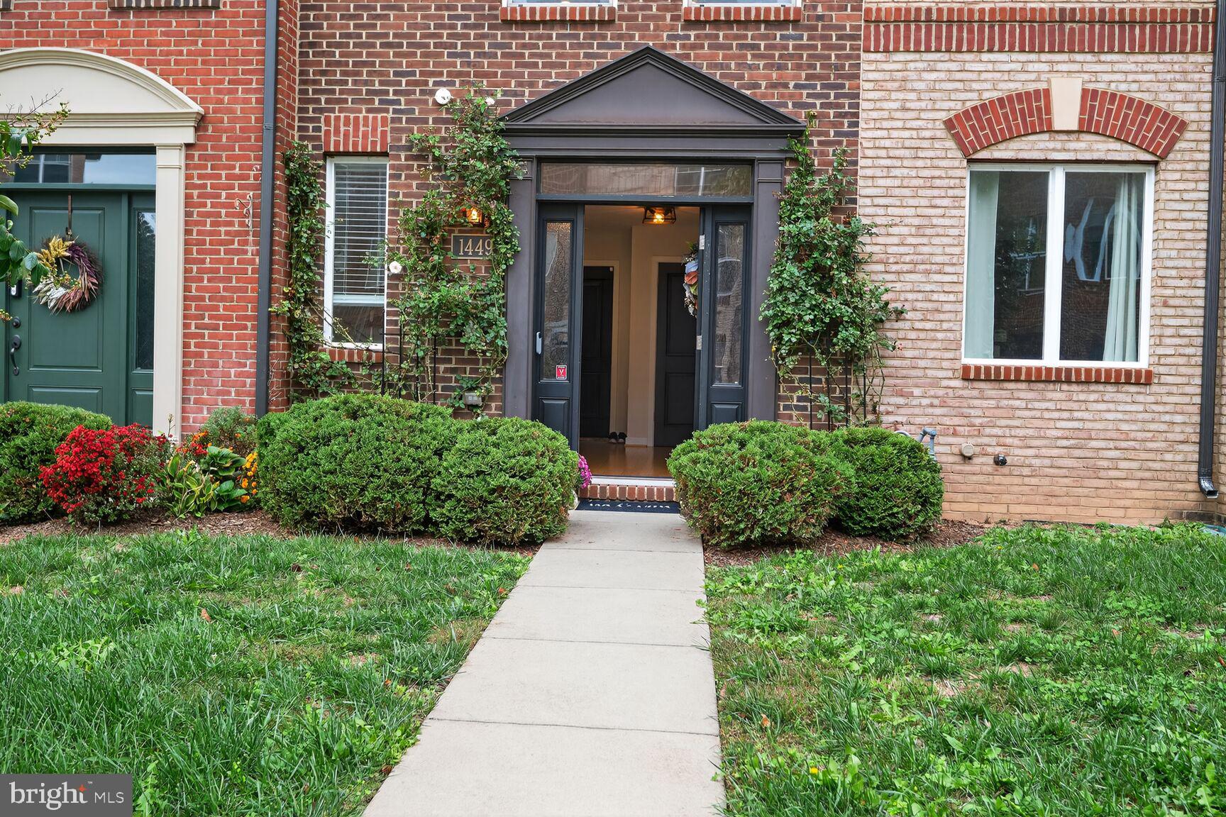 1449 Trafalgar Lane Frederick, MD 21701 - Photo 5 of 28 a view of a brick house with potted plants and a yard