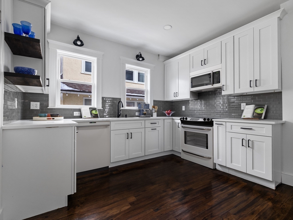 46 Sedgwick Street, Unit 2 Boston, MA 02130 - Photo 7 of 17 a kitchen with stainless steel appliances white cabinets a sink and wooden floor