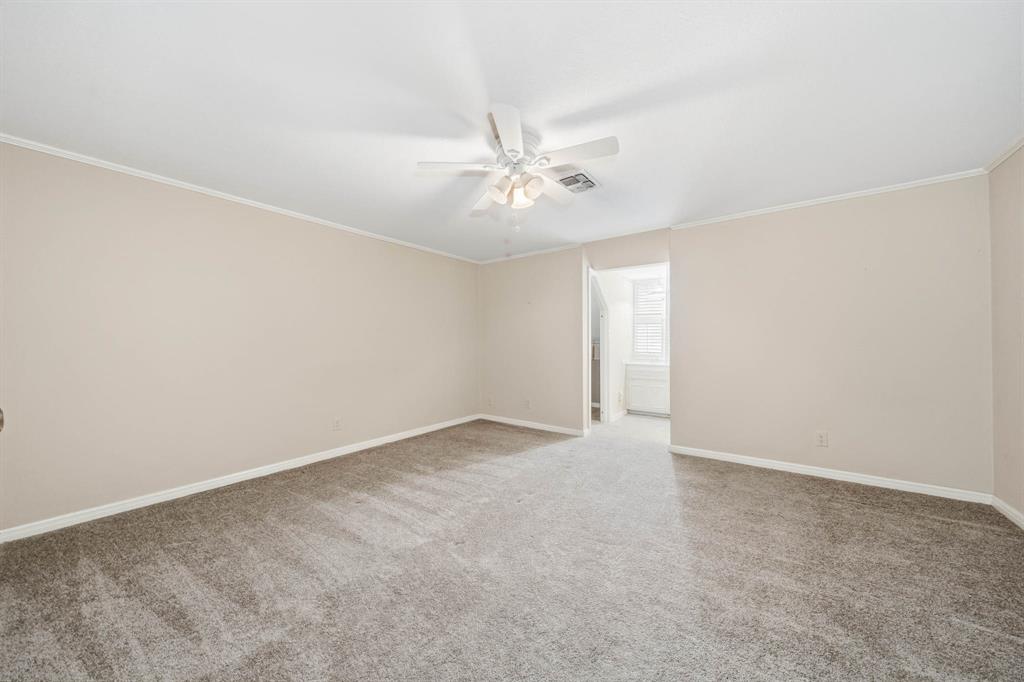 3400 Timbermill Road Waco, TX 76710 - Photo 23 of 35 an empty room with a chandelier fan and windows