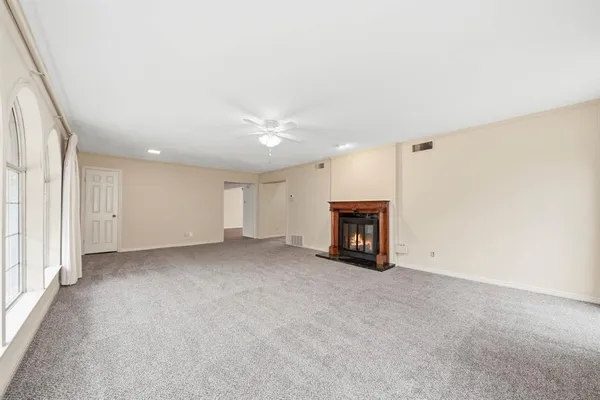 an empty room with fireplace and windows