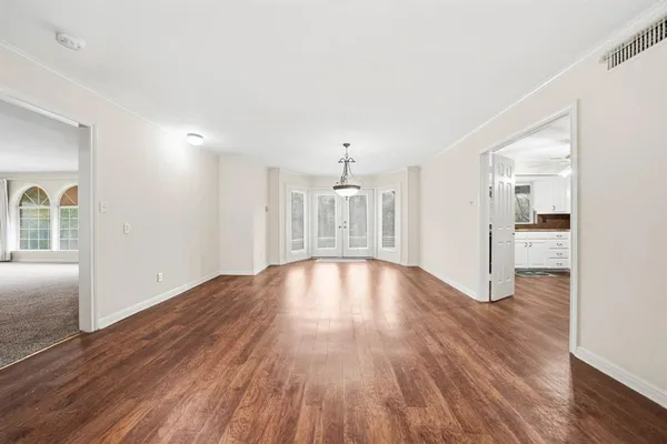 a view of empty room with wooden floor and fireplace