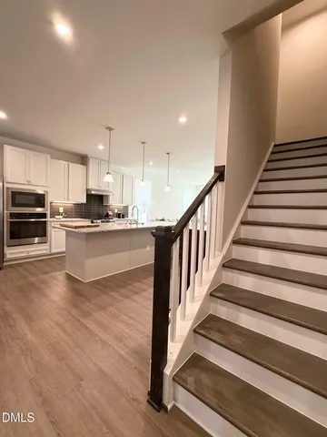 a view of kitchen with wooden floor and electronic appliances